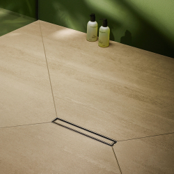 beige großformat hexagonfliesen mit schwarzem edelstahl duschrinnenrost und zwei grün-weißen seifenspendern vor grüner wand