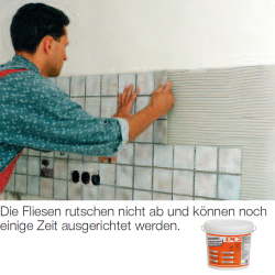 mann klebt hellgraue mosaikfliesen auf wand mit kammzug...