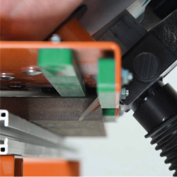 orange magnetbohrgerät mit grünen magnetfüßen und schwarzem absaugschlauch an betonplatte
