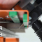 orange magnetbohrgerät mit grünen magnetfüßen und schwarzem absaugschlauch an betonplatte