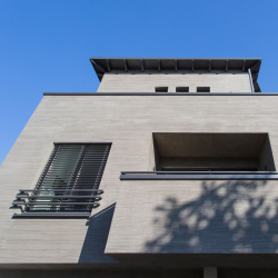 moderne hausfassade mit grauem strukturputz fenster mit schwarzen aluminiumjalousien und balkon