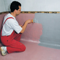handwerker streicht pci dichtungsanstrich grau auf pinke...